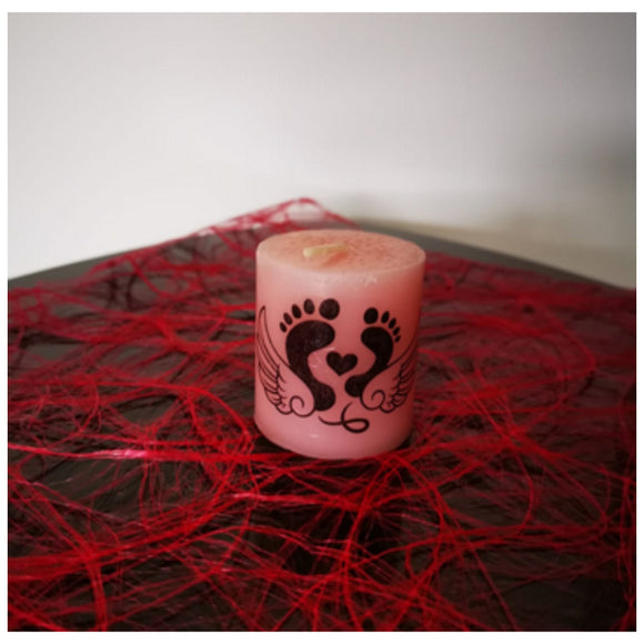 Eine kleine rosafarbene Kerze mit kleinen Füssen, Herz und Flügel bedruckt