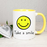 Tasse Weiß/Gelb mit Smiley und Spruch bedruckt: Take a smile