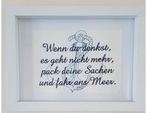 weißes Kunstleder blau bestickt mit Anker und Spruch in weißem Bilderrahmen mit Passepartout