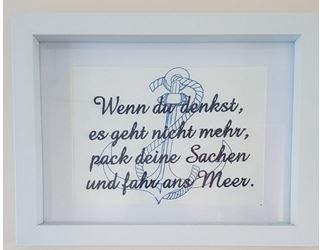 weißes Kunstleder blau bestickt mit Anker und Spruch in weißem Bilderrahmen mit Passepartout
