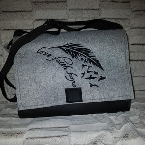 Umhängetasche aus Filz und Kunstleder mit verstellbarem Schultergut und Magnetverschluß.  Die Lasche ist bestickt mit einem schönen Motiv Feder, Vögel und Text love faith hope