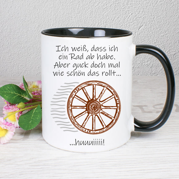 Tasse Weiß/Schwarz mit Spruch und Motiv bedruckt: Ich weiß, dass ich ein Rad ab habe. Aber guck doch mal wie schön das rollt...huuuiiiiii!