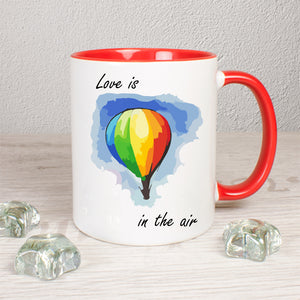 Tasse Weiß/Rot bedruckt mit Spruch: Love is in the air mit Heißluftballon